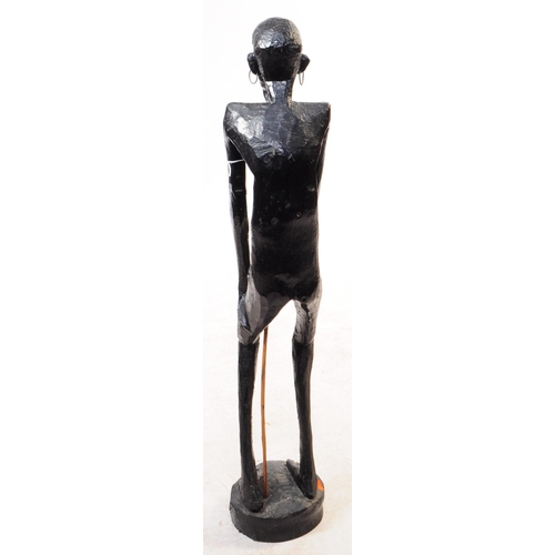 254 - A 20th century African ebonised wood statue figure. The figure in a standing position, raised on a r... 