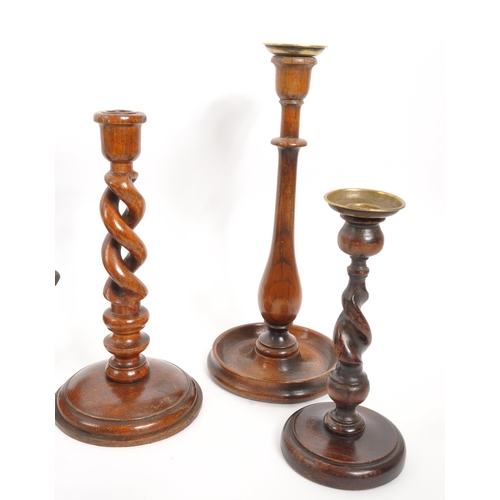 258 - A vintage collection of treen items. To include three pairs of wooden turned mahogany candlestick ho... 