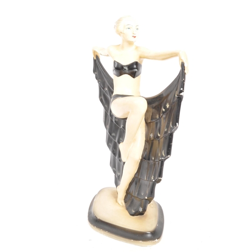 267 - A 20th Century Art Deco style plaster figurine in the form of a dancer. The figure facing sideways a... 