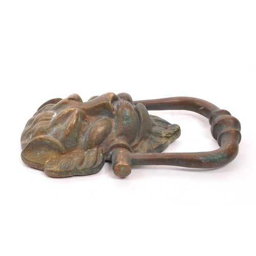 276 - A late 19th Century bronze ' lion mask ' door knocker with swing handle knocker. The lion with point... 