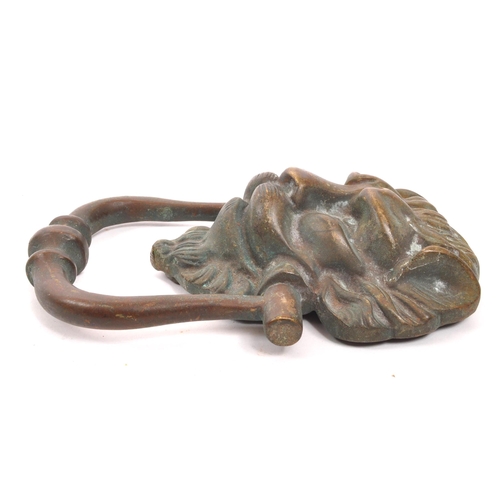 276 - A late 19th Century bronze ' lion mask ' door knocker with swing handle knocker. The lion with point... 