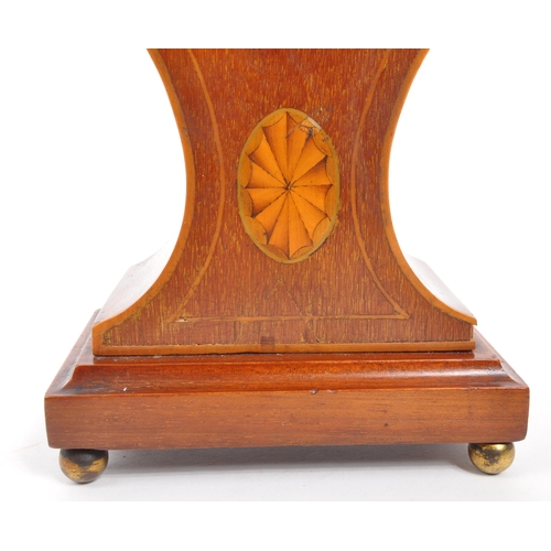 285 - An Edwardian walnut inlaid balloon shaped mantel clock with shell design inlay. Raised on rectangula... 