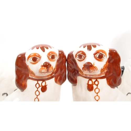 30 - Two pairs of 20th Century ceramic hand painted Staffordshire spaniel dogs. The larger examples black... 