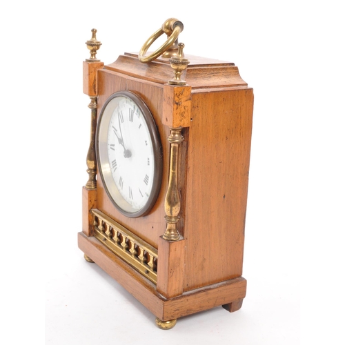 302 - An Edwardian walnut mantel clock with brass columns to either side and brass finials to the front co... 