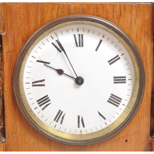 302 - An Edwardian walnut mantel clock with brass columns to either side and brass finials to the front co... 