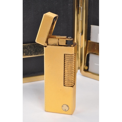 310 - Dunhill - A mid 20th century Dunhill lighter and cigarette case. The lighter having gold tone engine... 