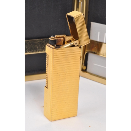 310 - Dunhill - A mid 20th century Dunhill lighter and cigarette case. The lighter having gold tone engine... 