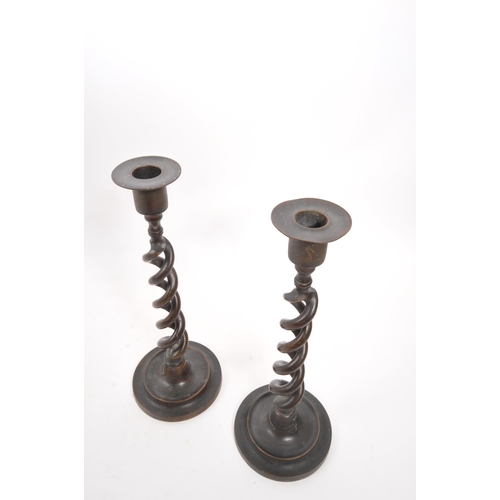 341 - A pair of vintage brass candlestick holders. Circular stepped bases with open barley twist columns a... 