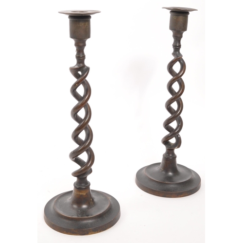 341 - A pair of vintage brass candlestick holders. Circular stepped bases with open barley twist columns a... 