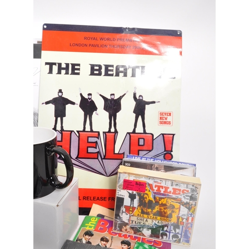 352 - The Beatles - a collection of assorted Beatles music memorabilia to include CDs, mugs, bags, tshirt,... 