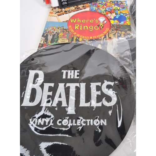 352 - The Beatles - a collection of assorted Beatles music memorabilia to include CDs, mugs, bags, tshirt,... 