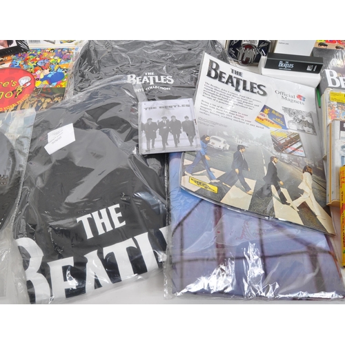 352 - The Beatles - a collection of assorted Beatles music memorabilia to include CDs, mugs, bags, tshirt,... 