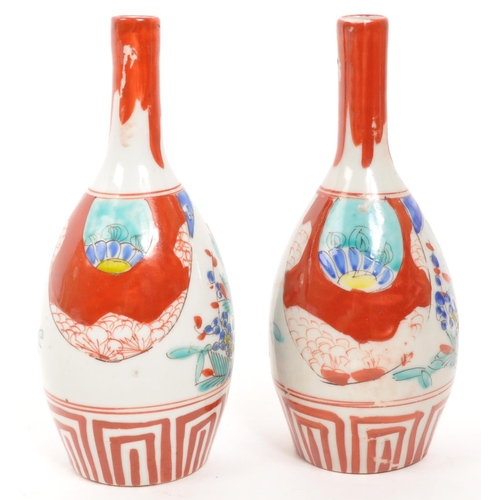 364 - A pair of vintage Japanese sake bottle / vases with an Imari palette dipicting bamboo and blossom mo... 