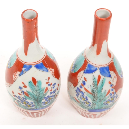 364 - A pair of vintage Japanese sake bottle / vases with an Imari palette dipicting bamboo and blossom mo... 