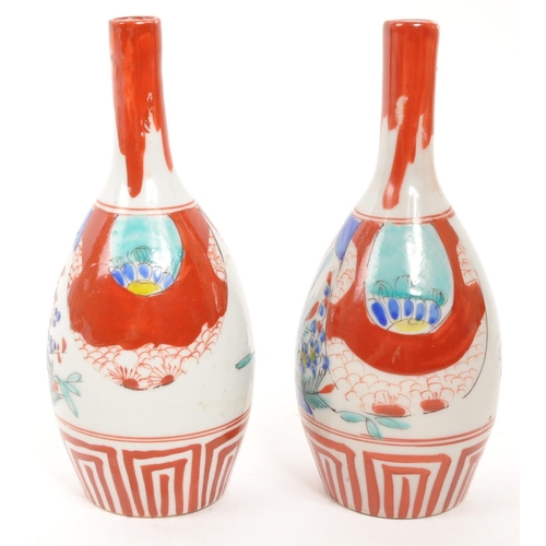 364 - A pair of vintage Japanese sake bottle / vases with an Imari palette dipicting bamboo and blossom mo... 