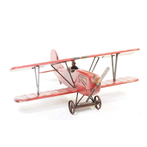 384 - A large 20th century carved wooden aeroplane model. The model painted in a red colourway, in the for... 