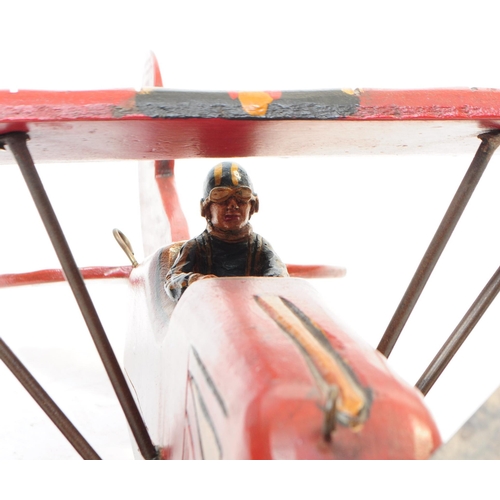 384 - A large 20th century carved wooden aeroplane model. The model painted in a red colourway, in the for... 