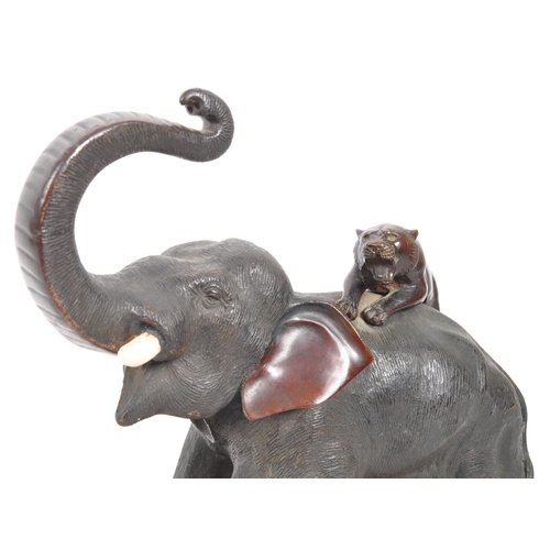 393 - A Meiji Period late 19th century bronze sculpture figure of an elephant fighting off tigers. AF. Wit... 