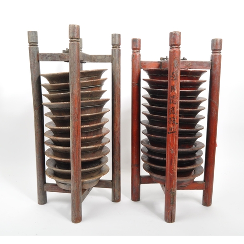 440 - A pair of wooden Chinese plate stacking caddy racks operated by releasing one of the wooden legs to ... 