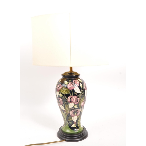 49 - Moorcroft - A mid century ceramic pottery Moorcroft lamp. Having a white shade, light fixing to top,... 