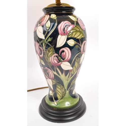 49 - Moorcroft - A mid century ceramic pottery Moorcroft lamp. Having a white shade, light fixing to top,... 