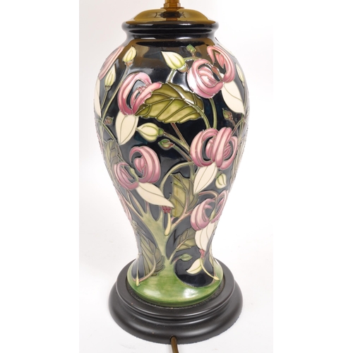 49 - Moorcroft - A mid century ceramic pottery Moorcroft lamp. Having a white shade, light fixing to top,... 