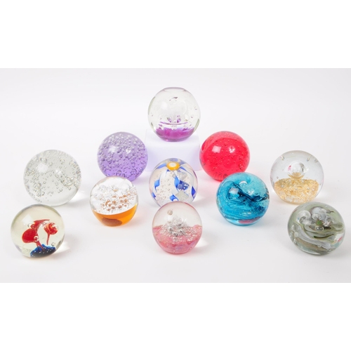 103 - A collection of eleven vintage 20th century bubble control glass paperweights. The lot to include fa... 