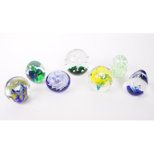 115 - A collection of x7 vintage 20th century glass paperweights. To include bubble control, floral and sw... 