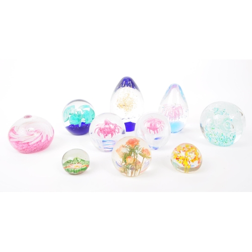 119 - A collection of x9 vintage glass paperweights, featuring bubbles, swirls and flowers in multiple col... 