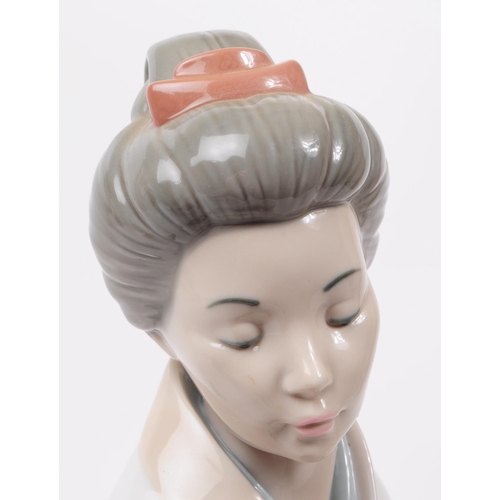 90 - LLadro, Spain - A large hand painted fine bone china porcelain figure of kneeling geisha. The figure... 