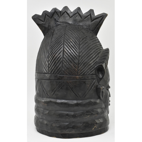 122 - A tribal Mende helmet mask (Ndoli Jowei) for Sande Society, the carved wooden helmet mask in form of... 