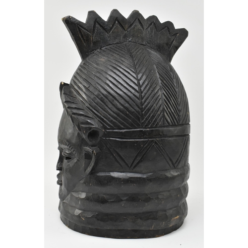 122 - A tribal Mende helmet mask (Ndoli Jowei) for Sande Society, the carved wooden helmet mask in form of... 