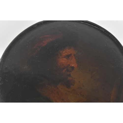 134 - An early 19th century papier mache lacquered snuff box. The circular lidded snuff painted with portr... 