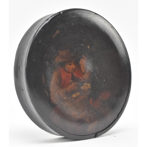 157 - A 19th century papier mache lacquered snuff box. The circular lidded snuff box painted with two card... 