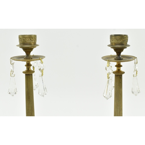 161 - A pair of French Empire 19th century brass & glass candlesticks. Each candlestick having a shape... 