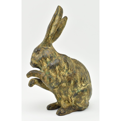 166 - A 20th century cast bronze figurine of a hare. The figure with textured design, modelled with paws &... 