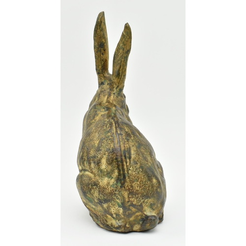 166 - A 20th century cast bronze figurine of a hare. The figure with textured design, modelled with paws &... 