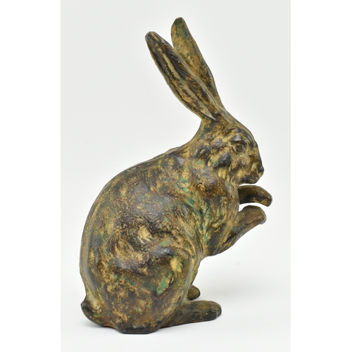 166 - A 20th century cast bronze figurine of a hare. The figure with textured design, modelled with paws &... 