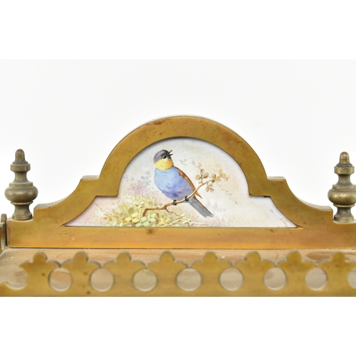 170 - A late 19th century French mantle clock with porcelain face. The clock featuring pediment with brass... 