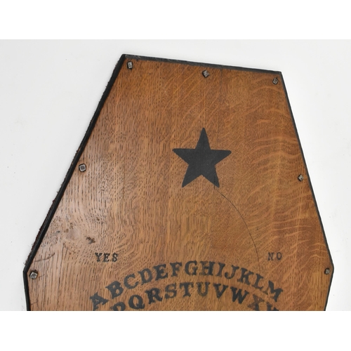 24 - Occultist interest. An early 20th century circa 1930s oak occult Ouija board in the form of a coffin... 