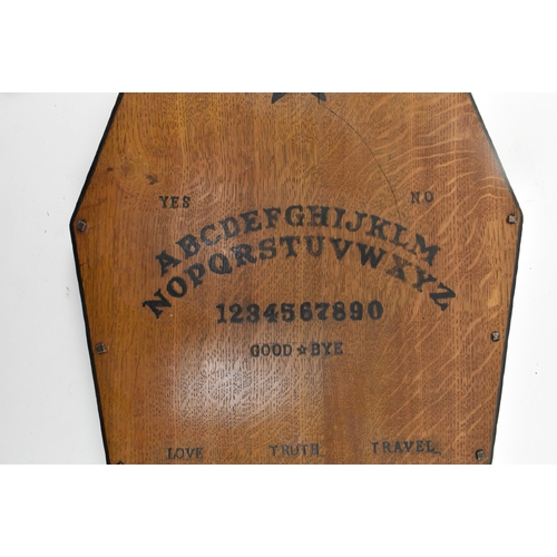 24 - Occultist interest. An early 20th century circa 1930s oak occult Ouija board in the form of a coffin... 