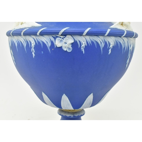 58 - A 19th century Wedgwood blue Jasperware Leda & Swan urn vase. The urn having a flared rim over t... 