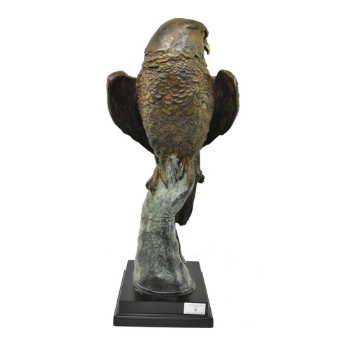 6 - A cast bronze figured sculpture of an eagle. The eagle depicted sitting atop a handler's gloved hand... 