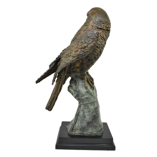 6 - A cast bronze figured sculpture of an eagle. The eagle depicted sitting atop a handler's gloved hand... 