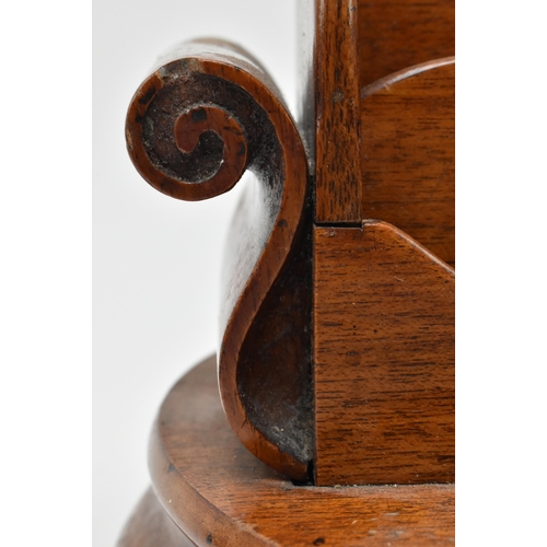 66 - A 19th century carved mahogany circular desk tidy with inkwells. The desk tidy having a central four... 