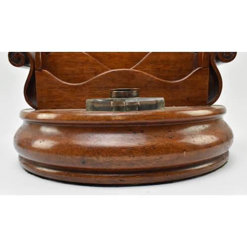 66 - A 19th century carved mahogany circular desk tidy with inkwells. The desk tidy having a central four... 