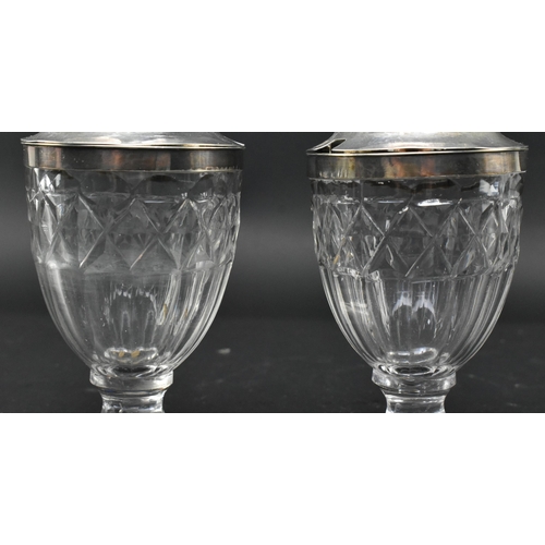 118 - A pair of early 19th century cut glass and silver plated condiment pots. Each with silver plated cir... 