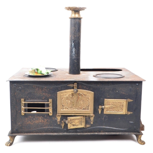 181 - A 19th century German Bavarian tin and brass plate table top children's stove. The stove having thre... 