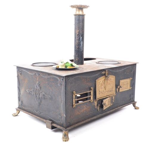 181 - A 19th century German Bavarian tin and brass plate table top children's stove. The stove having thre... 