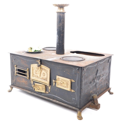 181 - A 19th century German Bavarian tin and brass plate table top children's stove. The stove having thre... 